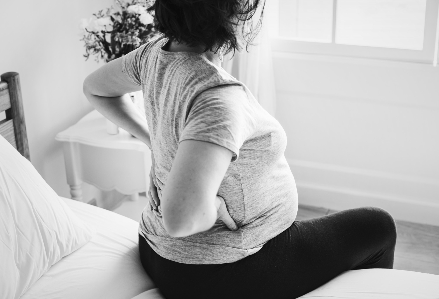 A pregnant woman sitting on a bed