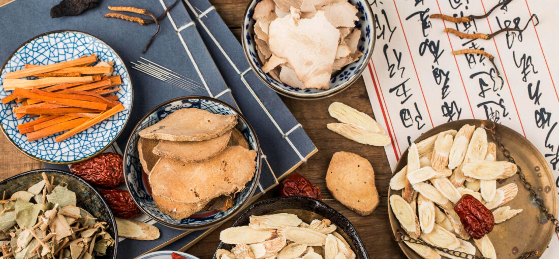 Chinese herbs in bowls on a table with chinese writing