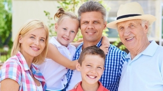 A family is posing for a photo in front of their home.